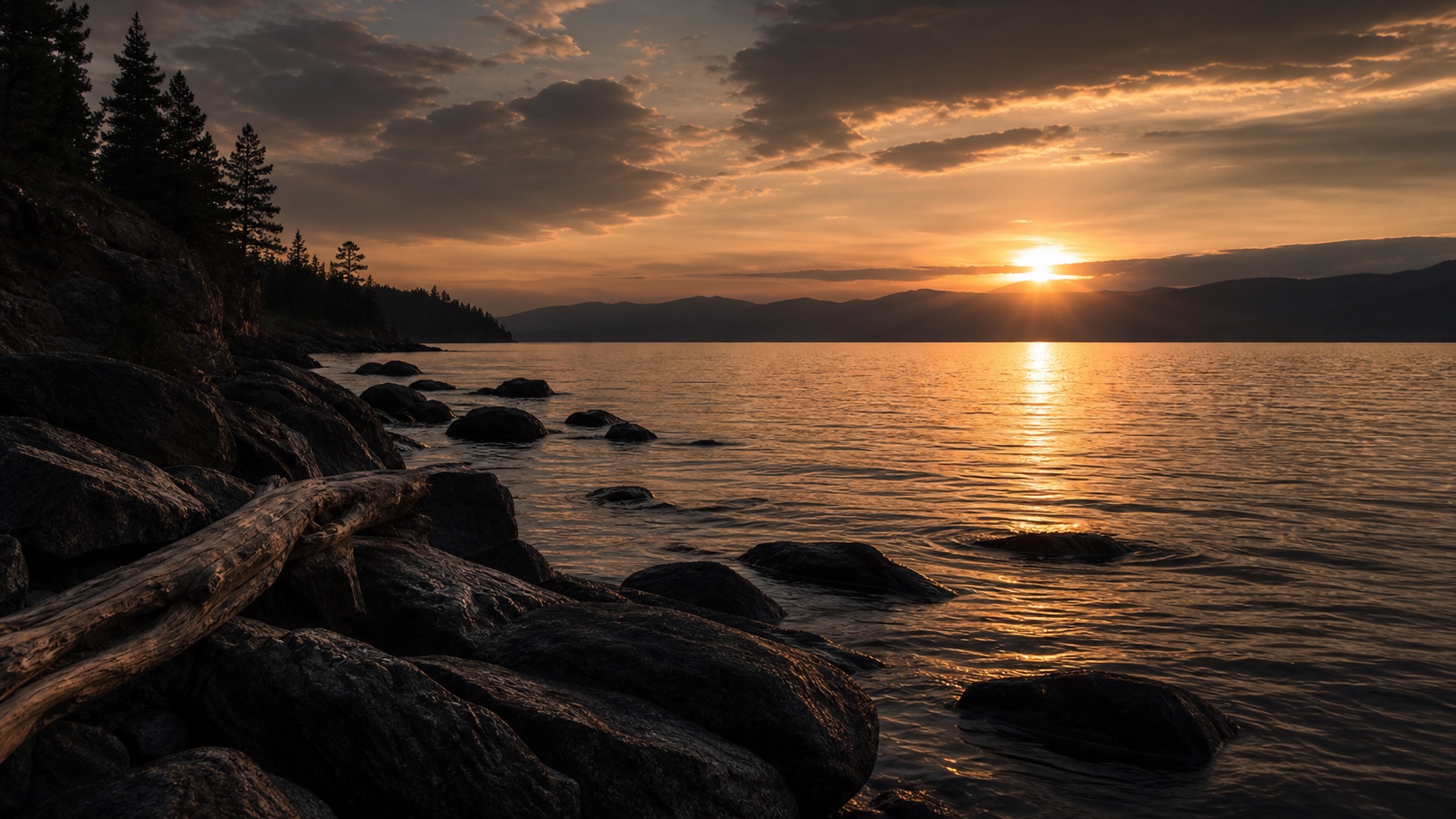A calm rocky shoreline at sunset.